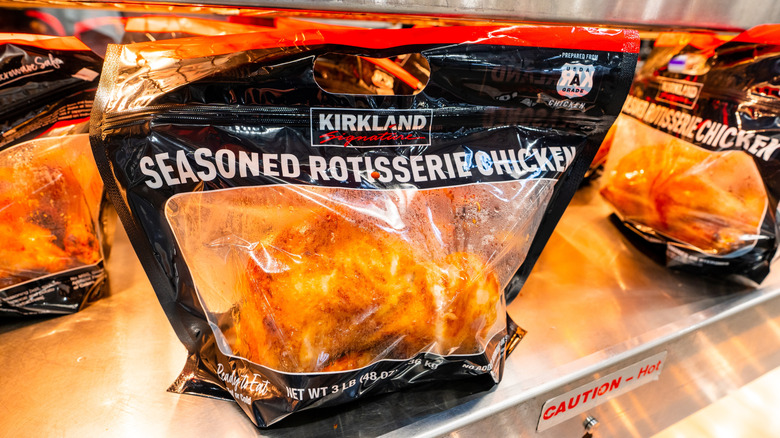 Kirkland Signature rotisserie chicken in black plastic bag on hot display shelf