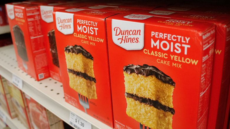 Boxes of Duncan Hines yellow cake mix on a grocery store shelf