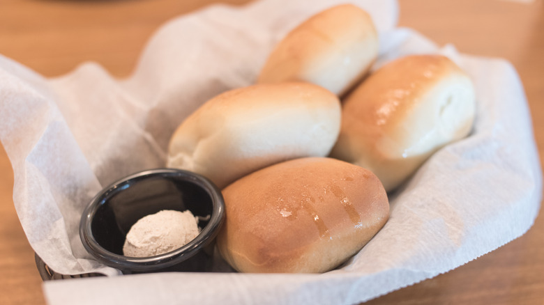 Texas Roadhouse rolls in basket with honey butter