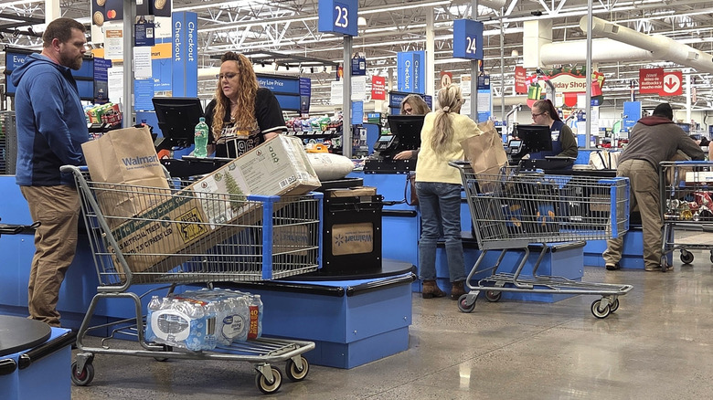 The cashier checkout area at Walmart with shoppers and cashiers visible