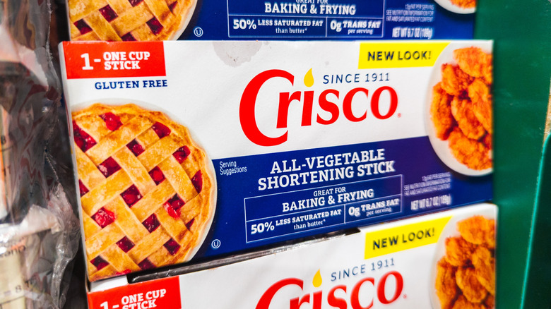 Sticks of Crisco stacked on grocery store shelf