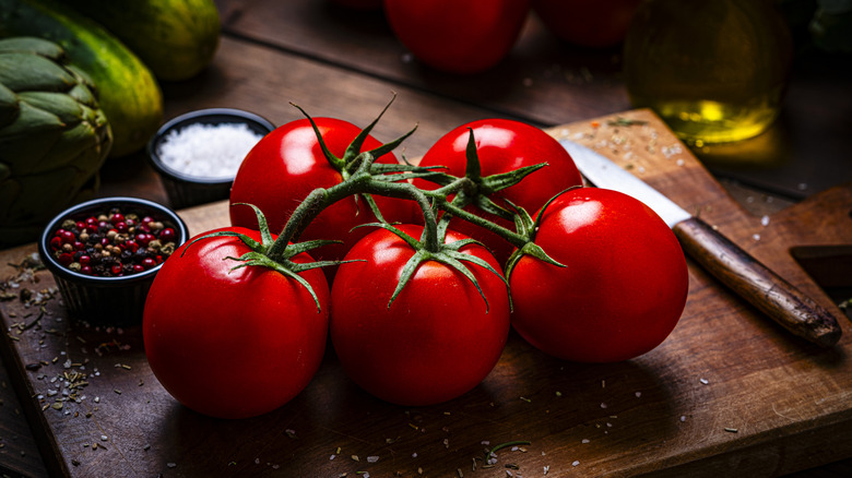 Tomatoes on cutting board with oil and salt