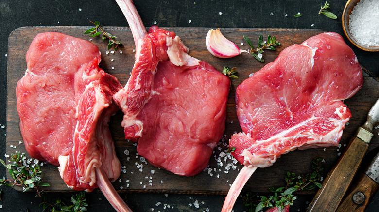 Raw veal chops on cutting board