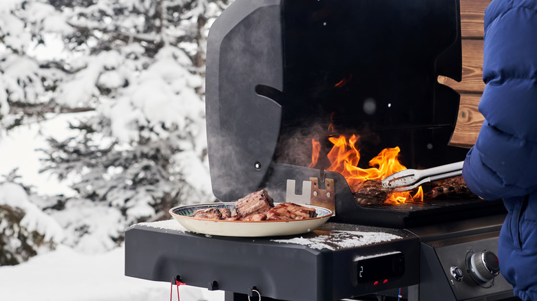 A person grilling in winter