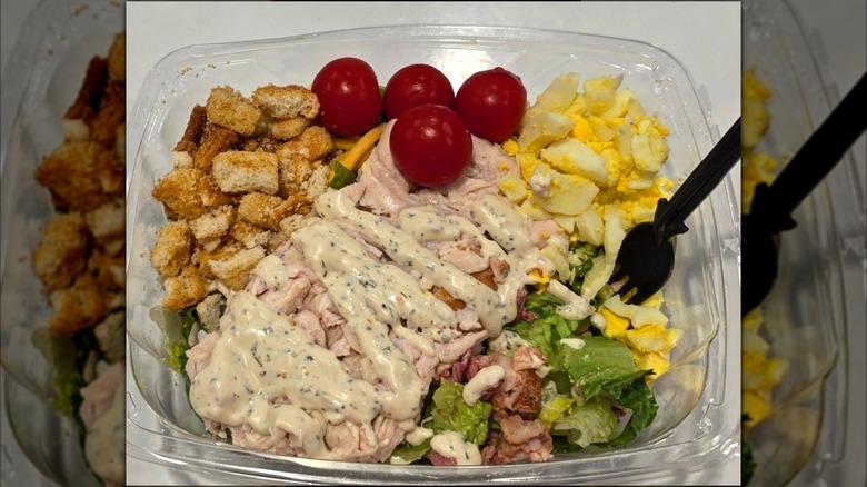 The Rotisserie Chicken Chef Salad from the Costco food court dressed and ready to eat with a fork stuck in it