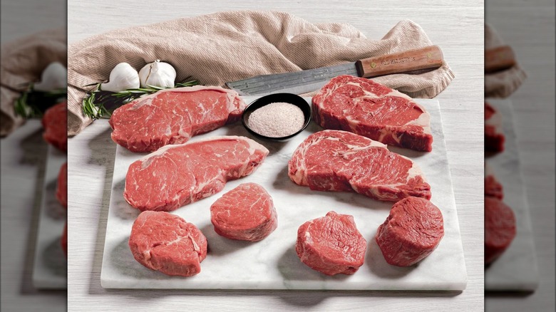 The box of eight steaks from Rastelli's at Costco beside a knife and herbs