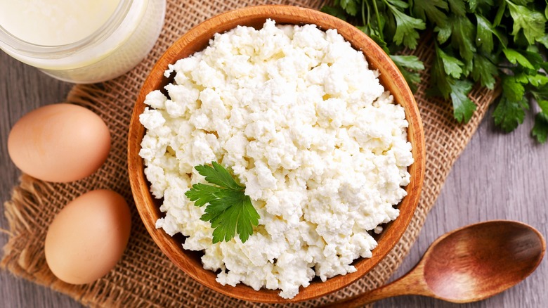 bowl of cottage cheese with eggs and herbs on the side