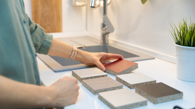 A woman looking at samples of different countertop materials