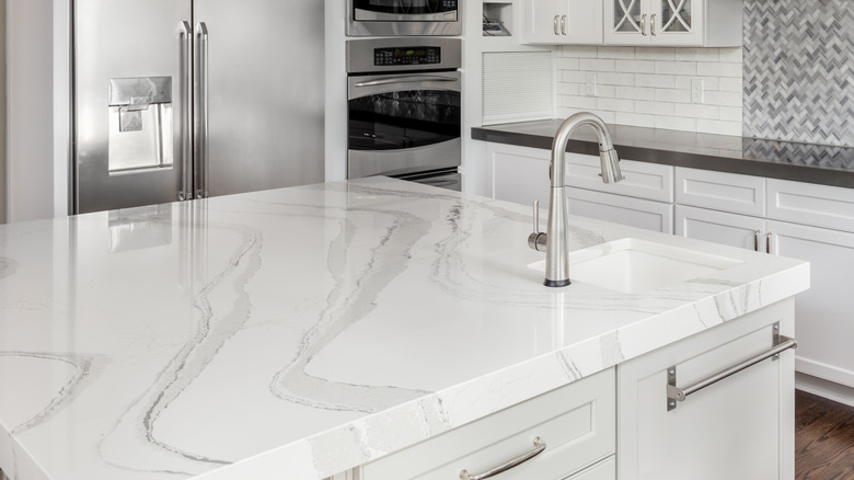 a white quartz kitchen counter with a sink