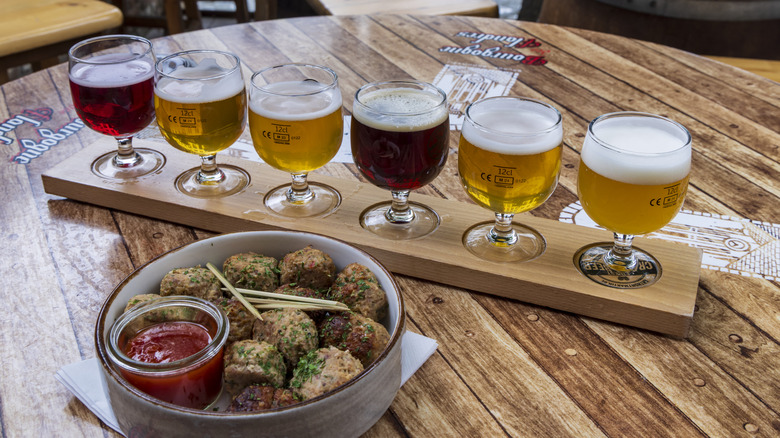Flight of different Belgian beers with plate of meatballs