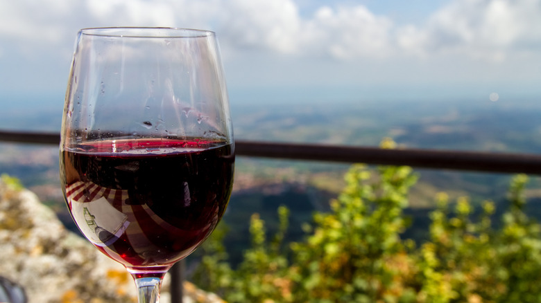 Glass of red wine against a background of the San Marino landscape