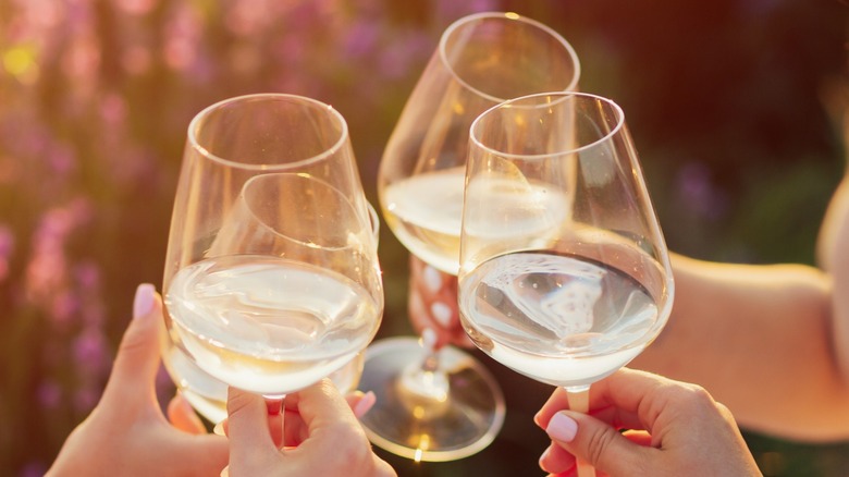 Hands toasting three wine glasses