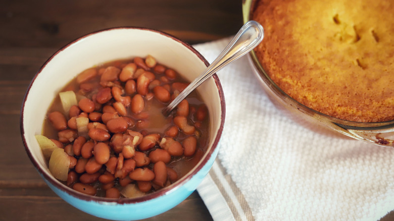 A bowl of beans and a baking dish of cornbread