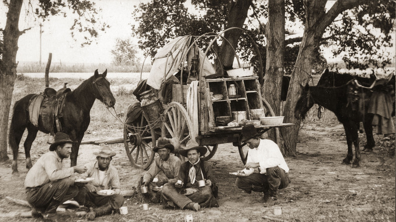 Cowboys around a chuckwagon in the Old West.