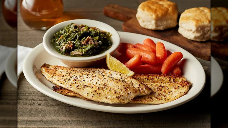 A plate of lemon pepper trout with carrots and greens