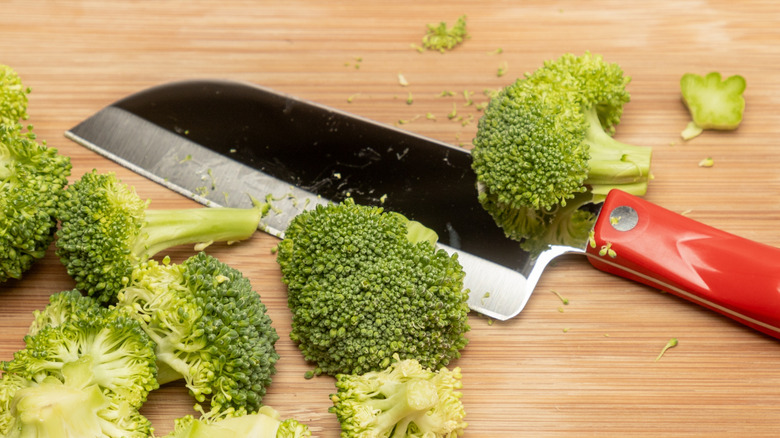 Single-bevel santoku knife on a cutting board with chopped broccoli