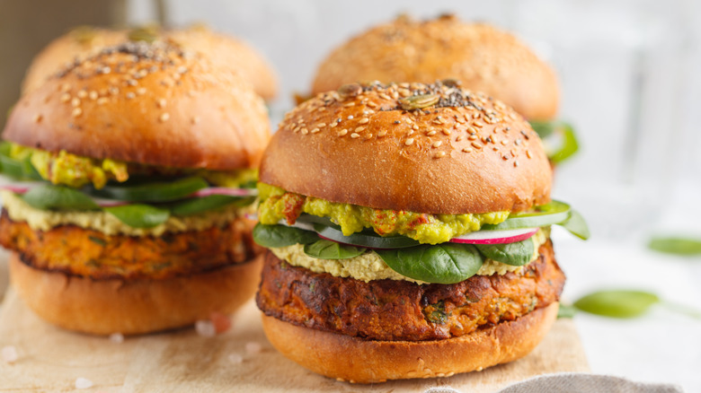 Three veggie burgers with grains and greens