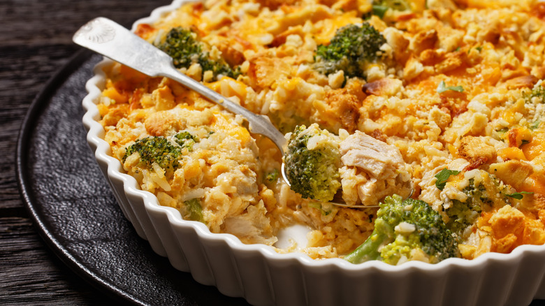 a spoon in a chicken and broccoli casserole topped with crushed crackers