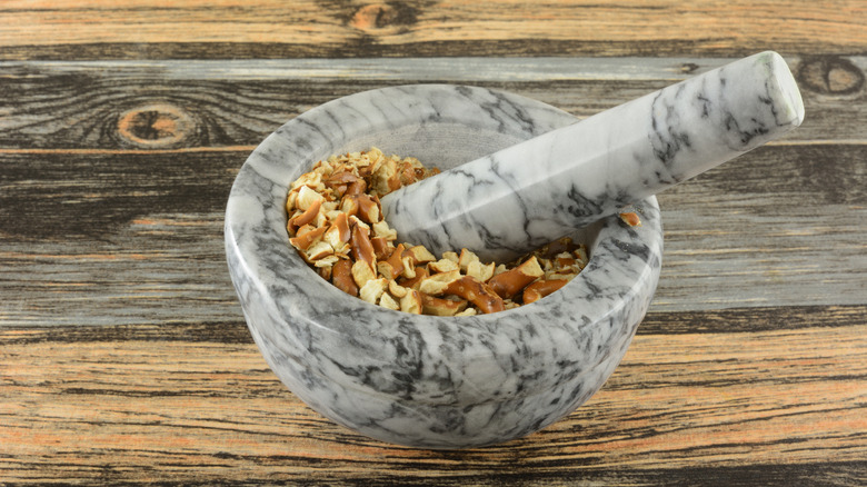 crushing pretzels with a mortar and pestle