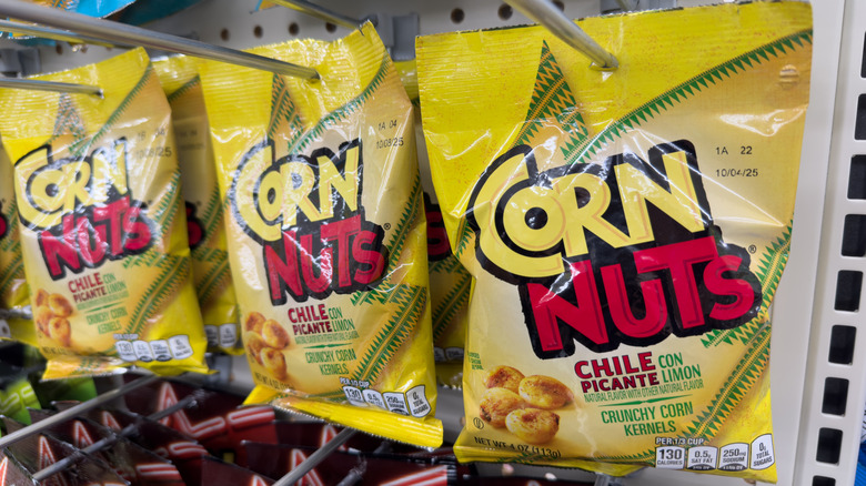 Yellow bags of Chile Picante Corn Nuts hanging in a store display.