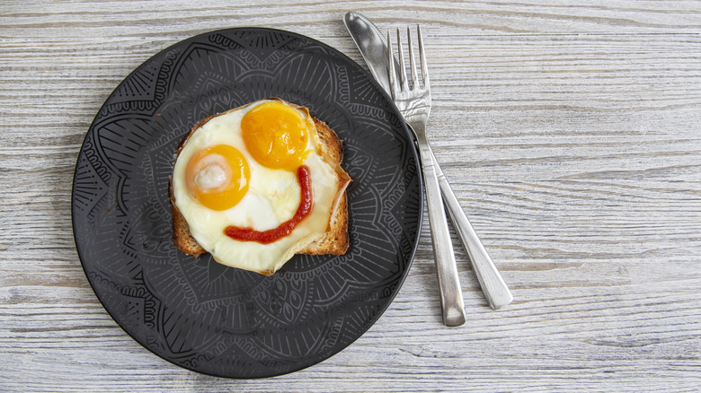 Eggs with ketchup, plated in a smiley-face design
