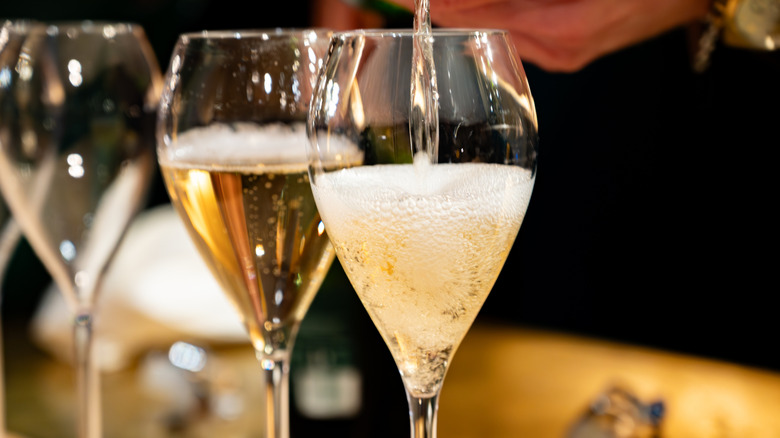 Two glasses of sparkling wine being poured