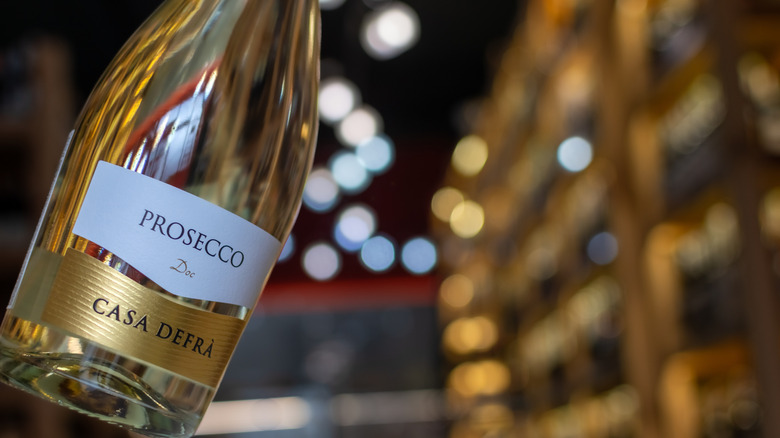 A bottle of Casa Defra prosecco with city lights in the background