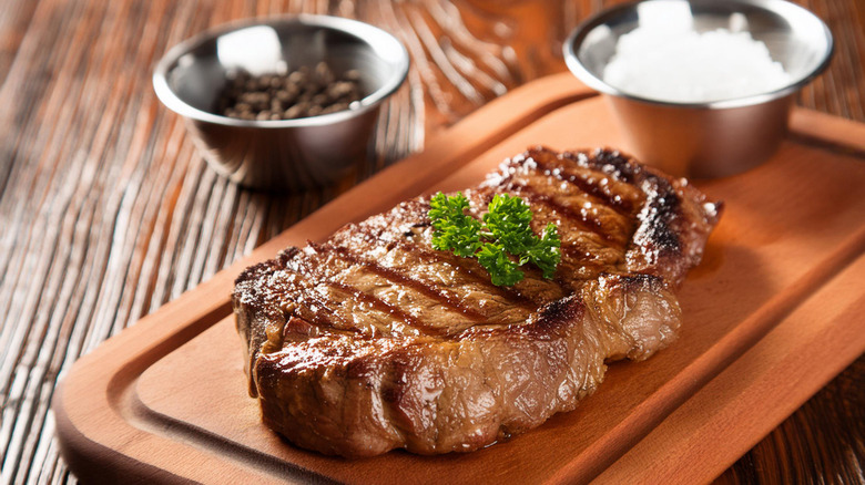 Grilled steak topped with curly parsley.