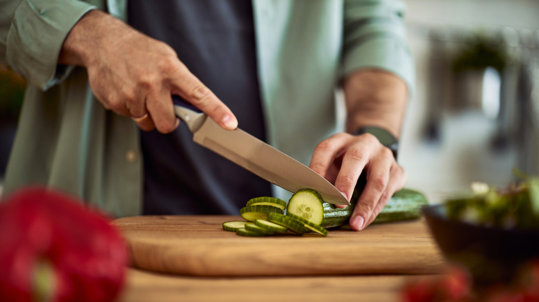 Hands chopping vegetables on cutting board