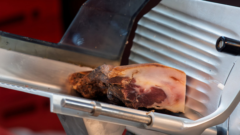 The end cut of a piece of deli meat on a slicer