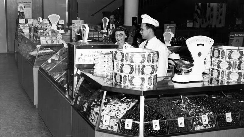 Two people behind the counter of a vintage Sears candy counter