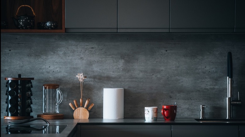 A kitchen with a natural stone looking wall rather than a backsplash