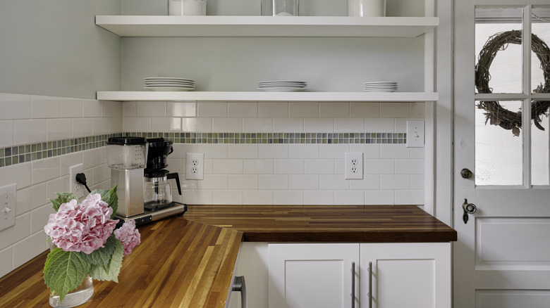 View of white kitchen with wood countertops