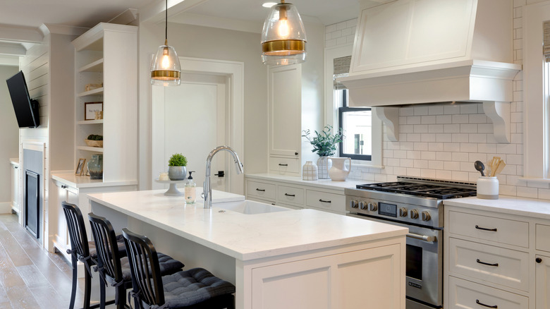 traditional white kitchen with center island and hanging lights