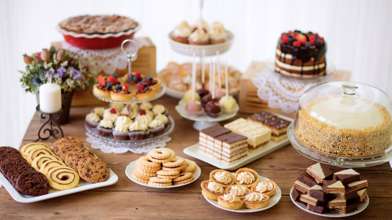 A dessert table full of cookies, cakes, and tarts
