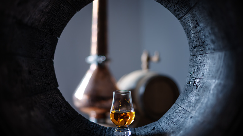 whiskey glass in oak barrel