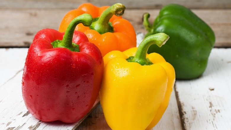 Whole red, orange, yellow, and green bell peppers