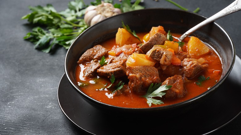 beef goulash in a black bowl