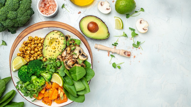 Chickpeas, spinach, mushrooms, and avocado in bowl