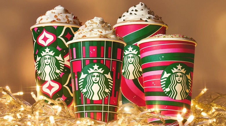 Starbucks holiday drinks amongst Christmas lights