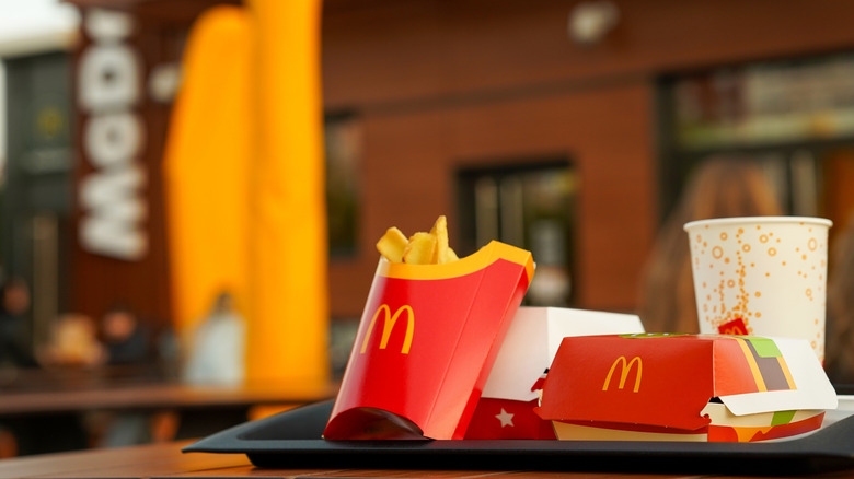 McDonald's meal sitting outside of restaurant with box fries and drink