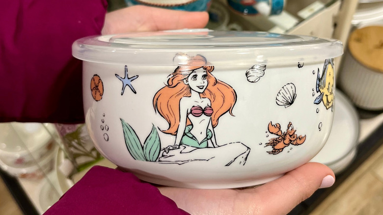 Woman holding a bowl featuring Ariel from The Little Mermaid