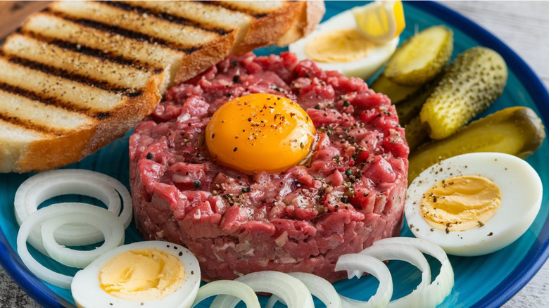 steak tartare with toast, gherkins and onion