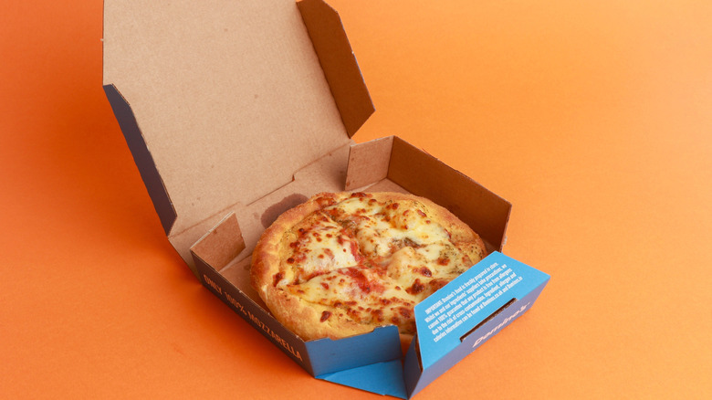 An open pizza box with Domino's in it