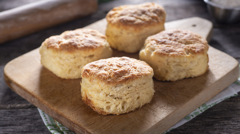 four biscuits on cutting board
