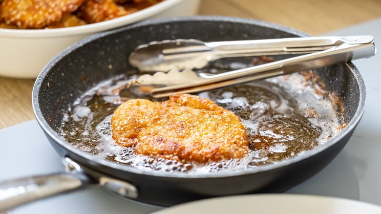 chicken frying in pan