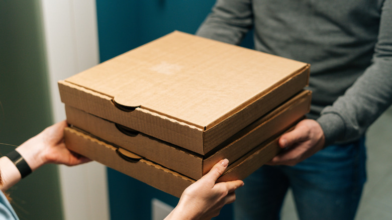 Person holding delivery pizzas