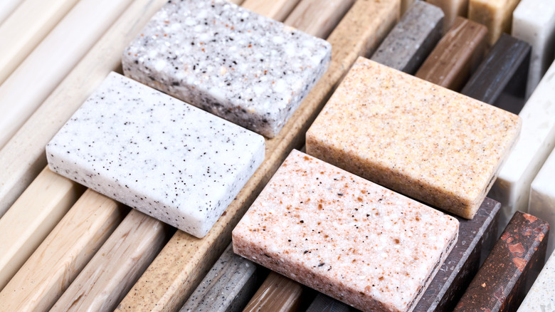 A selection of marble stone countertops with four small rectangles sitting atop a longer selection of different looks