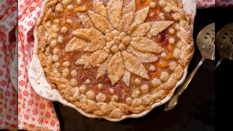 A homemade pie with a poinsettia decoration on top made from pie crust