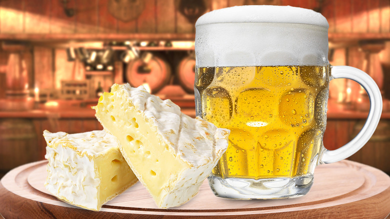 Close-up of a mug of beer next to two wedges of cheese